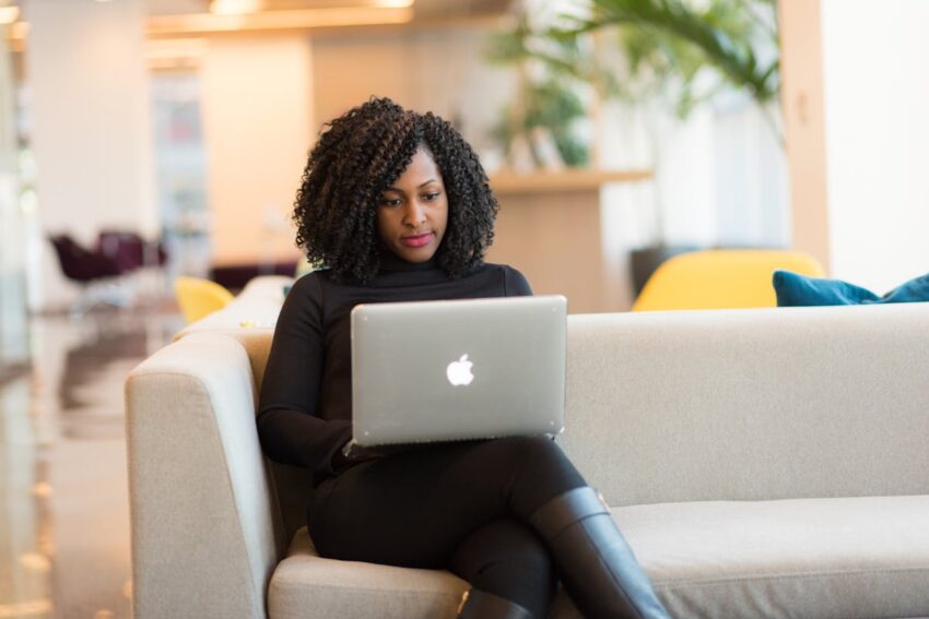 A Black woman is looking at her laptop screen